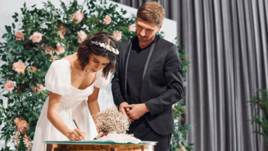 gorgeous white couple signing wedding insurance documents up on a stage
