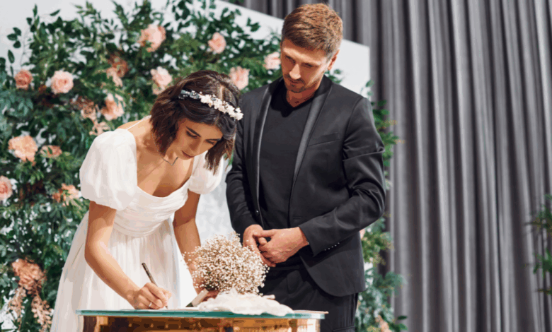 gorgeous white couple signing wedding insurance documents up on a stage